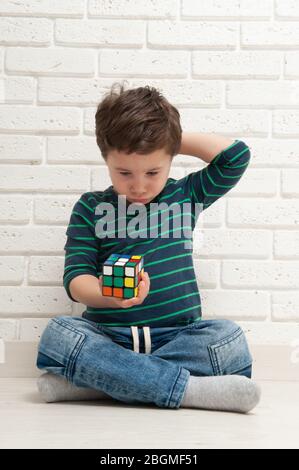 Kiew, Ukraine, 22. märz 2020. Boy spielt mit rubik's Würfel. Rubik's Cube erfunden von einem ungarischen Architekten Erno Rubik im Jahr 1974. Stockfoto