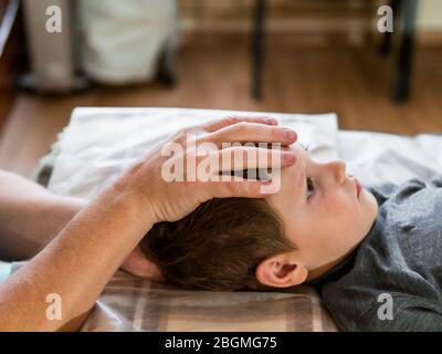 Osteopathie-Behandlung. Elementares Alter die Stirn des Jungen wird von einem echten osteopathischen Arzt manipuliert Stockfoto