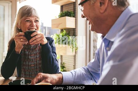 Senior paar Gespräch beim Kaffee zusammen trinken im Cafe. Lächelnd zog sich Mann und Frau im Cafe sitzen Reden und Kaffee Stockfoto