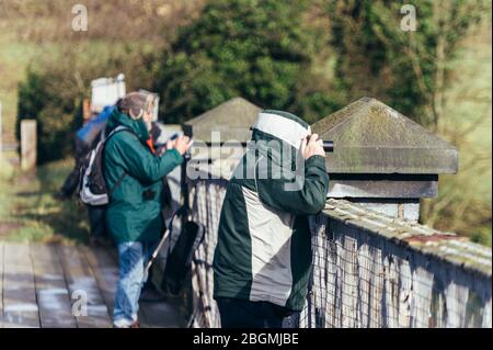 Zugspotter auf einer Brücke mit Kameras warten auf eine Lok funktionierende britische Dampflokomotive, die Sir Nigel Gresley (LNER Klasse A4 Pacific 4498 Stockfoto