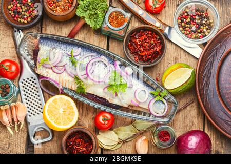 Gesalzene Heringe mit roter Zwiebel auf altem Holzhintergrund. Rustikale Küche Stockfoto