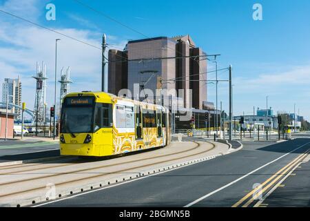 Metrolink Straßenbahn nähert sich dem Quay West Gebäude am Eröffnungstag der Trafford Park Linie. Trafford Wharf Rd., Trafford, Manchester, Großbritannien Stockfoto