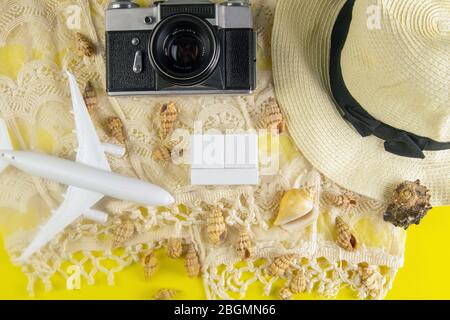 Sommerkonzept. Reisezubehör: Strohhut, Kamera, Seil, Flugzeug, Muscheln und Holzwürfel Stockfoto
