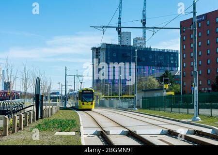 Metrolink Straßenbahn nähert sich der Haltestelle Wharfside am Eröffnungstag der Trafford Park Line, 22. März 2020. Wharfside, Old Trafford, Manchester, Großbritannien Stockfoto