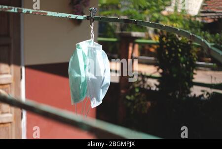 Waschen und trocknen Maske für die Wiederverwendung zu covid-19 in der Nähe des Hauses zu schützen und hängen an Wäscheleine Stockfoto