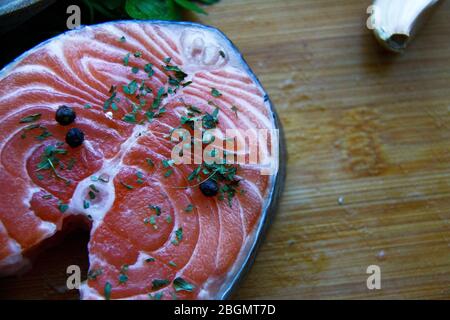 Frischer, roher, ungekochter Lachs auf Holzschneidebrett aus nächster Nähe. Gesundes Essen Konzept. Stockfoto