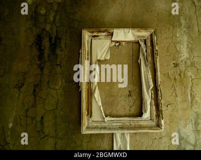 Leerer Rahmen auf zerstörter Mauer in Pripjat bei Tschernobyl, Ukraine. Stockfoto