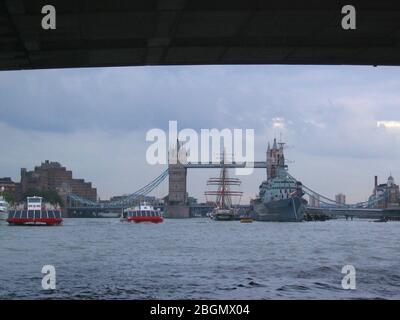 Blick unter der London Bridge in Richtung Tower Bridge mit HMS Belfast und der Prinz William Tall Trainingsschiff neben London England GB Stockfoto