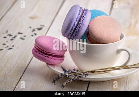 Makronen in Tasse mit Lavendel auf Untertasse Stockfoto