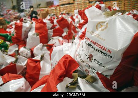 Jakarta, Jakarta, Indonesien. April 2020. Arbeiter packen Sozialhilfepakete (Sozialhilfe) im Cipinang Food Station Warehouse, Jakarta, 22. April 2020. Die Regierung verteilte Sozialhilfepakete für drei Monate, um die Bewohner davon abzuhalten, nach Hause zu gehen, und um während der COVID-19-Pandemie die Kaufkraft für bedürftige Bewohner im Großraum Jakarta zu erhöhen. Kredit: Dasril Roszandi/ZUMA Wire/Alamy Live News Stockfoto