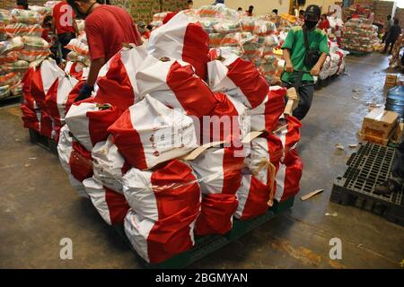 Jakarta, Jakarta, Indonesien. April 2020. Arbeiter packen Sozialhilfepakete (Sozialhilfe) im Cipinang Food Station Warehouse, Jakarta, 22. April 2020. Die Regierung verteilte Sozialhilfepakete für drei Monate, um die Bewohner davon abzuhalten, nach Hause zu gehen, und um während der COVID-19-Pandemie die Kaufkraft für bedürftige Bewohner im Großraum Jakarta zu erhöhen. Kredit: Dasril Roszandi/ZUMA Wire/Alamy Live News Stockfoto