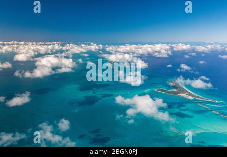 Luftaufnahme der Bahama Inseln und des umliegenden blauen Wassers, mit kleinen flauschigen weißen Wolken auf den Bahamas Stockfoto