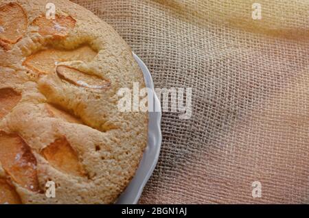 Leckere Torte mit Quitten-Scheiben. Hausgemachte süße Quitten-Pie. Traditionelle runde Torte auf Burlap. Backen mit Scheiben Obst. Ansicht von oben in einem Winkel. Nahaufnahme Stockfoto