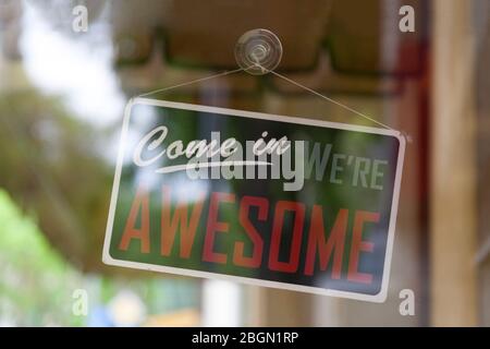 Nahaufnahme auf einem offenen Schild im Fenster eines Shops, das sagt: "Komm herein, wir sind fantastisch". Stockfoto