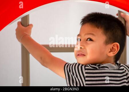 Portrait von asiatischen Jungen sind die Leiter in den Spielplatz. Stockfoto