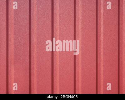 Detail des neuen roten Metallzauns mit vertikalen Rippen der Steifigkeit Stockfoto