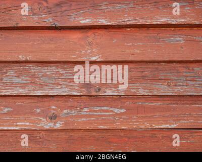 Detail des alten verwitterten Holzdaches in rot mit horizontal überlagerten parallelen Brettern Stockfoto