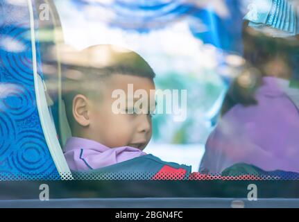 Asiatische junge sitzt auf einem Schulbus. Stockfoto