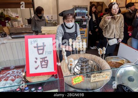 Eine alte Frau verkauft ihren Yaki Dango in ihrem eigenen Laden vor dem Asakusa-Tempel in Tokio, Japan, 7. Februar 2020 Stockfoto