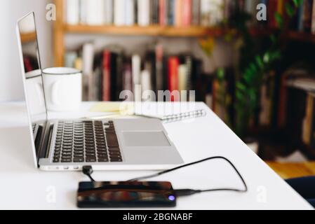 Ein weißer Schreibtisch mit Laptop, Festplatte und Kaffee ist in Nahaufnahme zu sehen Stockfoto