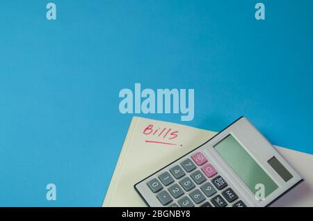 Rechnungen. Notizblock mit Rechner auf der blauen Farbtabelle. Kopierbereich. Stockfoto