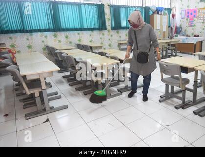 Jakarta, Indonesien. April 2020. Ein Lehrer reinigt ein Klassenzimmer an einer Grundschule in Jakarta, Indonesien, 22. April 2020. Laut lokalen Medien stellte die örtliche Regierung einige Schulen als Unterkunft für medizinisches Personal zur Verfügung. Kredit: Zulkarnain/Xinhua/Alamy Live News Stockfoto