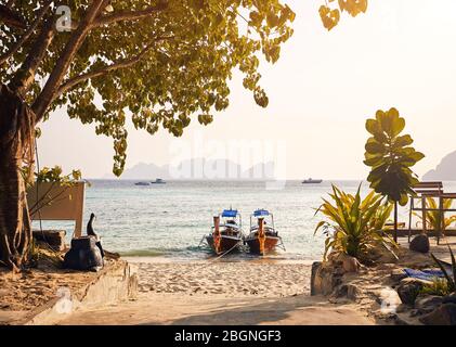 Long tail Boote am tropischen Strand bei Sonnenuntergang auf Koh Phi Phi Island, Thailand Stockfoto