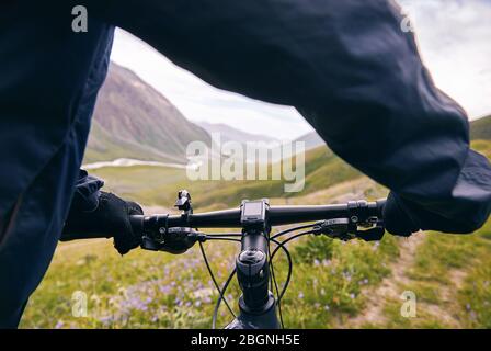 Die Hände am Lenker Mountainbike in der Mountain Road close up Stockfoto