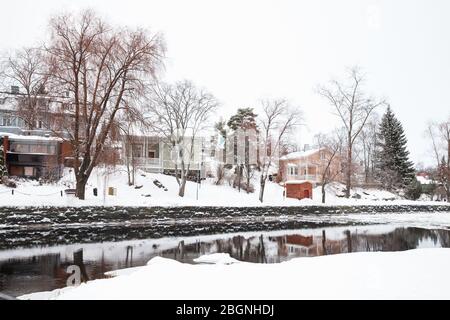 Landschaft von Savonlinna, Finnland im Winter. Kleine Wohnhäuser sind an der verschneiten Flussküste Stockfoto