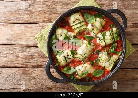 Italienische Küche Zucchinibrot mit Ricotta-Käse und Kräutern in Tomatensauce in einer Pfanne auf einem Tisch Nahaufnahme gebacken. Horizontale Draufsicht von oben Stockfoto