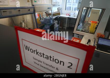 Techniker führen während der Eröffnung des neuen Covid-19-Testlabors am Queen Elizabeth University Hospital in Glasgow einen Probentransfer durch. Stockfoto