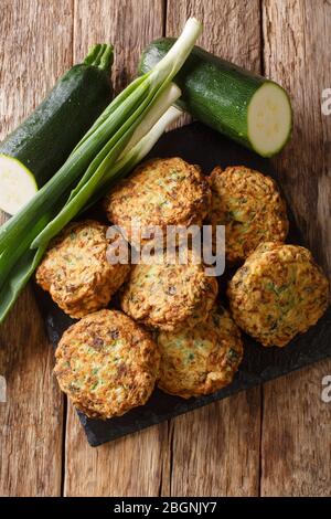 Vegetarische griechische Zucchini Kugeln kolokithokeftedes close-up auf einem Schiefertafel auf dem Tisch. Vertikale Ansicht von oben Stockfoto