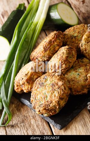 Zucchinibugeln mit Zutaten Nahaufnahme auf einem Schiefertafel auf dem Tisch. Vertikal Stockfoto