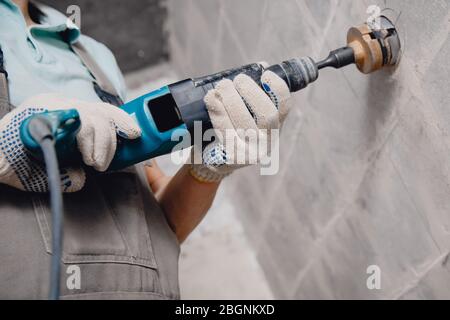 Bauherr schneidet elektrische Verfolgungsjagd in Betonwand mit Hammer-Bohrer-Rautenkrone Stockfoto
