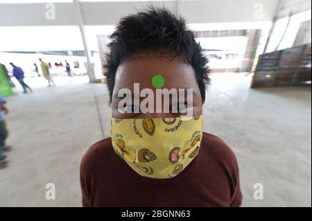 Bangkok, Thailand. April 2020. Ein Kind trägt das Zeichen auf seiner Stirn, nachdem es am 22. April 2020 an einem kostenlosen Lebensmittelverteilungsort in Bangkok, Thailand, eine Temperaturkontrolle durchgeführt hat. Die thailändischen Behörden äußerten am Mittwoch Vertrauen in die jüngste Abwärtsentwicklung der COVID-19-Fallkurve, bei der 15 neue Fälle und ein Todesfall gemeldet wurden. Kredit: Rachen Sageamsak/Xinhua/Alamy Live News Stockfoto