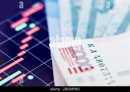 Russische Rubel-Banknoten vor dem Hintergrund der fallenden roten Währungen Grafik. Konzept wirtschaftliche Standard, Öl Stockfoto