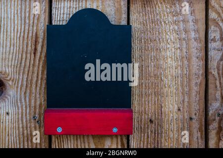 Leere Kreidetafel auf einem Holzstand mit rotem Regal für kostenlose Etikettierung Stockfoto