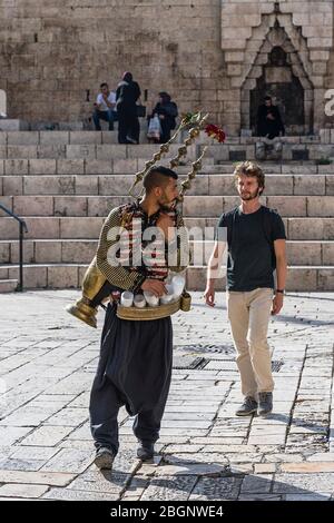 Israel, Jerusalem, Ostjerusalem, EIN palästinensischer Araber mit seiner kupfernen Teekanne auf dem Rücken verkauft ein kaltes Getränk aus Tamarindensaft und Rosenwasser am Damasttor. Stockfoto