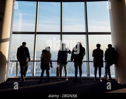 Das Silhouette-Foto von Touristen im Tokyo Sjytree Dock, die durch eine Fensterbrille auf den Fuji Berg und die Stadt Tokio schauen. Tokio, Japan F Stockfoto