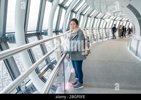 Eine Thailänderin in grauem Pullover und rosa Schal blickt vom Deck des Tokyo Skytree Turms auf die Stadt Tokio. Tokio, Japan, 7. Februar 2020 Stockfoto