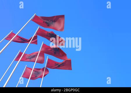 Albanienflaggen winken im Wind gegen einen blauen Himmel. 3D-Rendering Stockfoto