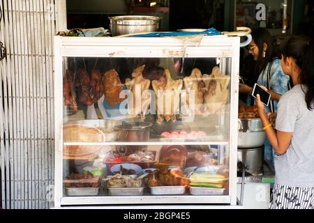 Thailändische Frauen und Reisende kaufen Hainanese Chicken Rice Betong-Stil und andere Speisen im lokalen Street-Food-Restaurant in Betong Stadt in Yala, Thailan Stockfoto