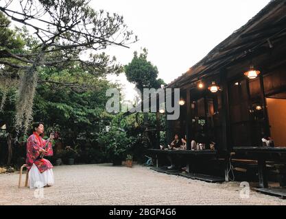 Naha Okinawa, 21. Mai 2019 - EINE Frau, die im Restaurant einen sanshin spielt und ein traditionelles Okinawan Kostüm trägt. Stockfoto