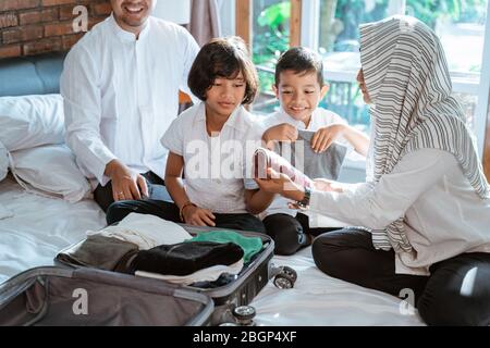 Muslimische Familie bereiten Kleidung und Koffer für getragen, wenn Mudik ins Dorf gehen Stockfoto