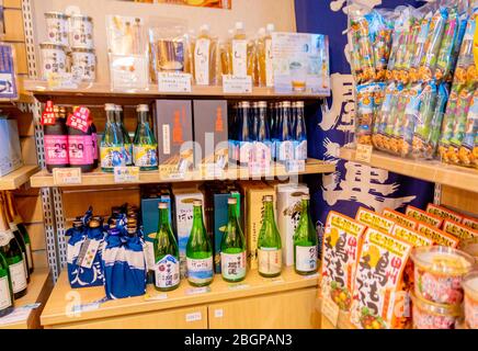 Lokaler japanischer Sake in grünen Flaschen in Regalen in der Herb Hall am See Kawaguchiko, Tokio, Japan 9. Februar 2020 Stockfoto