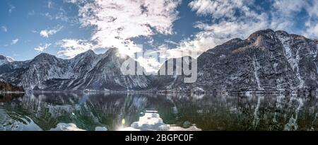 Panoramablick auf verschneite Berge rund um das österreichische Dorf Hallstatt am See im Winter mit klarem, sonnigem Wetter Stockfoto