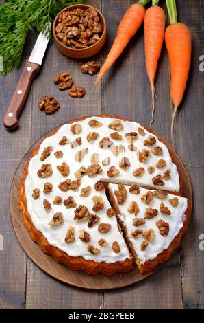 Karottenkuchen auf Holzhintergrund. Walnuss und frische Karotten auf dem Tisch Stockfoto