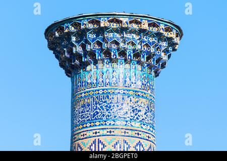 Details der Spitze eines Minaretturms in Ulugh Beg Madrasah in der Region Registan, Samarkand, Usbekistan. Details der islamischen Kunst, Keramikfliesen und Majolika Stockfoto