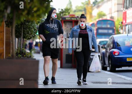 London, Großbritannien. 22. April 2020 - Menschen, die Gesichtsmasken tragen, während der Sperrung des Coronavirus im Norden Londons. Die Öffentlichkeit wird gebeten, Gesichtsmasken in der Öffentlichkeit zu tragen, um die Verbreitung von COVID-19 zu stoppen. Kredit: Dinendra Haria/Alamy Live News Stockfoto