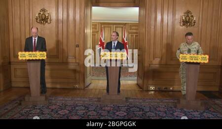 Bildschirmschnappung von (von links nach rechts) Chief Medical Officer für England Chris witty, Außenminister Dominic Raab, Chef des Verteidigungspersonals General Sir Nick Carter während einer Medienbesprechung in Downing Street, London, über Coronavirus (COVID-19). Stockfoto